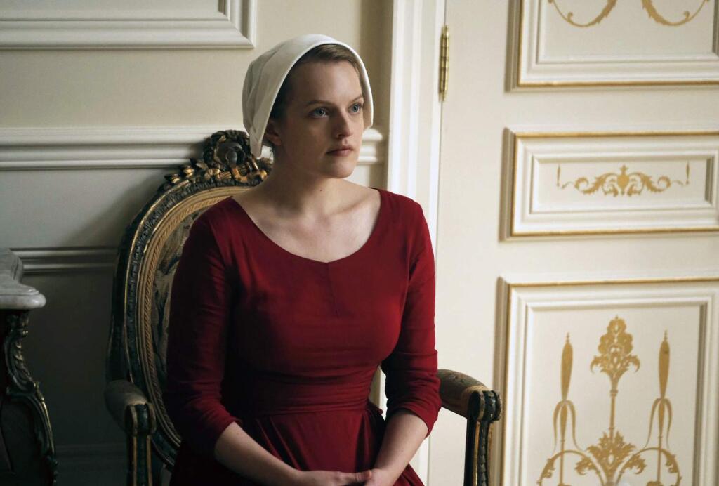 This image released by Hulu shows Elisabeth Moss as Offred in a scene from, 'The Handmaid's Tale,' premiering Wednesday on Hulu with three episodes. The remaining seven hours will be released each Wednesday thereafter. (George Kraychyk/Hulu via AP)