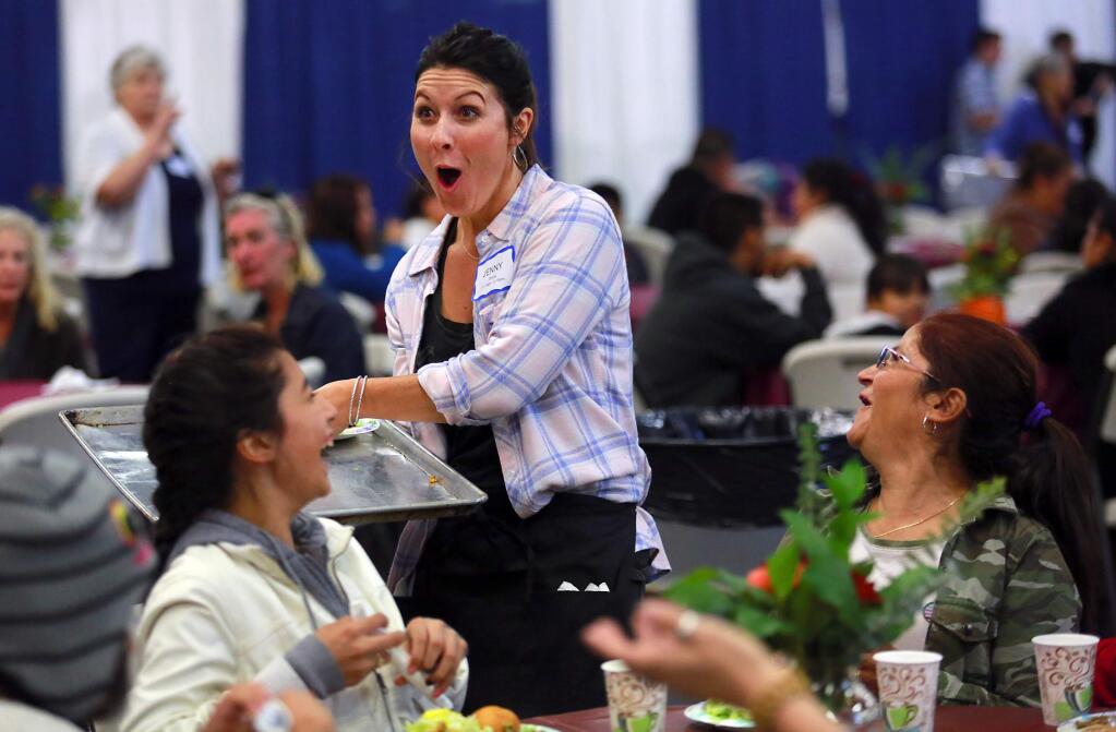 Jenny Craighead reacts after nearly spilling a turkey dinner for Zulema Reyes, 12, left, and Maria Flores at the Redwood Gospel Mission Great Thanksgiving Banquet at the Sonoma County Fairgrounds on Wednesday. (JOHN BURGESS / The Press Democrat)