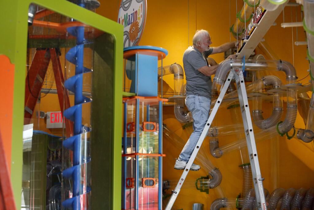 Jim Cunningham, a volunteer from the Redwood Empire Garden Railway Society, fine tunes one of the two overhead railroads at the Children's Museum of Sonoma County in Santa Rosa, on Tuesday, June 16, 2015. (BETH SCHLANKER/ The Press Democrat)