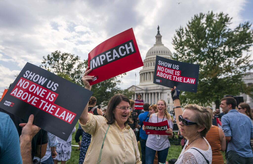 Activists rally for the impeachment of President Donald Trump, at the Capitol in Washington, Thursday, Sept. 26, 2019. Speaker of the House Nancy Pelosi, D-Calif., committed Tuesday to launching a formal impeachment inquiry against Trump. (AP Photo/J. Scott Applewhite)