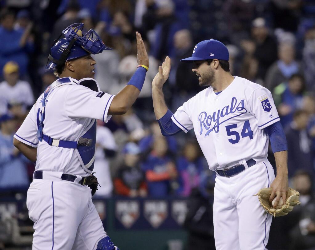 Kansas City Royals catcher Salvador Perez and relief pitcher Scott Alexander (54) celebrate after their baseball game against the Chicago White Sox, Monday, May 1, 2017, in Kansas City, Mo. Kansas City won 6-1. (AP Photo/Charlie Riedel)