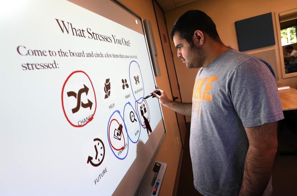 (File photo) Isa House, 19, circles some of the things that cause him stress on a 'smart board' in the Becoming Independent Passport to Independence Program for people with autism. (JOHN BURGESS / The Press Democrat)
