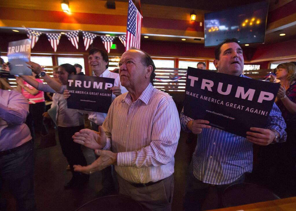 Cle Elum resident Sno Benavides, center, celebrates early Washington primary results showing a wide-margin victory for Republican presidential candidate Donald Trump at Cask and Trotter, Tuesday, May 24, 2016, in Lynwood, Wash. Standing to the right of Sno is his nephew Chente Benavides. (Sy Bean/The Seattle Times via AP) SEATTLE OUT; USA TODAY OUT; MAGS OUT; TELEVISION OUT; NO SALES; MANDATORY CREDIT TO BOTH THE SEATTLE TIMES AND THE PHOTOGRAPHER