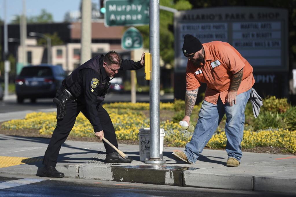 Police and road crews work to clean up the scene after a car crash at the intersection of El Camino Real and Sunnyvale Road in Sunnyvale, Calif., on Wednesday, April 24, 2019. Investigators are working to determine the cause of the crash in Northern California that injured several pedestrians on Tuesday evening. Authorities say the driver of the car was taken into custody after he appeared to deliberately plow into the group. (AP Photo/Cody Glenn)
