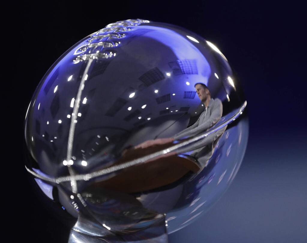 New England Patriots quarterback Tom Brady is reflected in the Lombardi Trophy during a news conference after the NFL Super Bowl 51 football game Monday, Feb. 6, 2017, in Houston. (AP Photo/David J. Phillip)