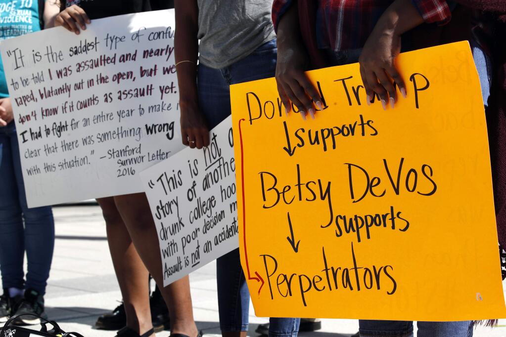 People gather to protest proposed changes to Title IX before a speech by Education Secretary Betsy DeVos, Thursday, Sept. 7, 2017, at George Mason University Arlington, Va., campus. DeVos plans to end the Obama administration's rules for investigating allegations of sexual violence on campus. DeVos said 'The era of 'rule by letter' is over,' as she announced plans to review and replace the way colleges and university handle investigations. (AP Photo/Jacquelyn Martin)
