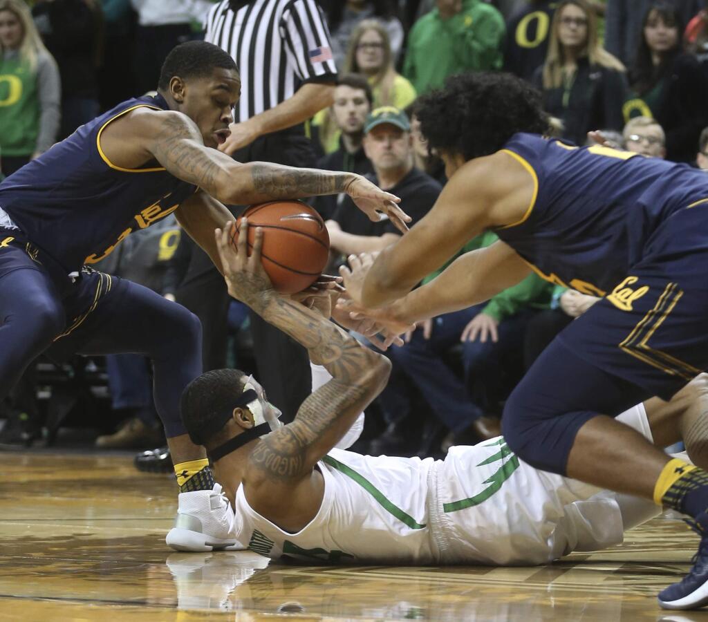 California's Paris Austin, left, and Audre Kelly, right, try to get the ball from Oregon's Kenny Wooten, center, during the first half of an NCAA college basketball game Wednesday, Feb. 6, 2019, in Eugene, Ore. (AP Photo/Chris Pietsch)
