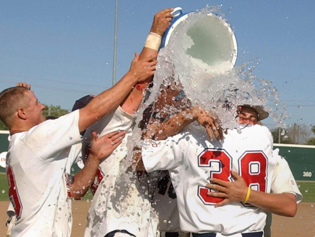 SRJC baseball coach Damon Neidlinger is surrounded by his players in a celebratory shower after the Bear Cubs captured the state baseball championship in 2005, the first of two state titles won by Neidlinger's teams. (Crista Jeremiason / The Press Democrat)