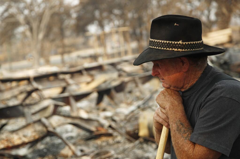 Ed Bledsoe rests as he searches through what remains of his home, Monday, Aug. 13, 2018, in Redding, Calif. Bledsoe's wife, Melody, great-grandson James Roberts and great-granddaughter Emily Roberts were killed at the home in the Carr Fire. (AP Photo/John Locher)
