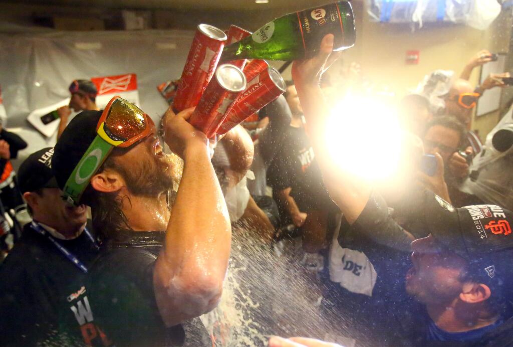 San Francisco Giants starting pitcher Madison Bumgarner chugs four beers and champagne while celebrating with his teammates in the locker room following Game 5 of the National League Championship Series against the St. Louis Cardinals in San Francisco on Thursday, Oct. 16, 2014.(CHRISTOPHER CHUNG/ PD)