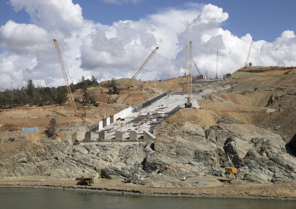 In this Sept. 21, 2017 photo, crews work to repair the damaged spillway on the Oroville Dam in Oroville, Calif. California is launching an overall safety review of the nation's tallest dam to pinpoint any needed upgrades or repairs in the half-century-old dam, water officials said Wednesday, Nov. 1, 2017. An independent national panel of dam-safety experts had called for that kind of overarching review at Oroville Dam in September following last winter's collapse of the dam's two spillways. (AP Photo/Rich Pedroncelli)