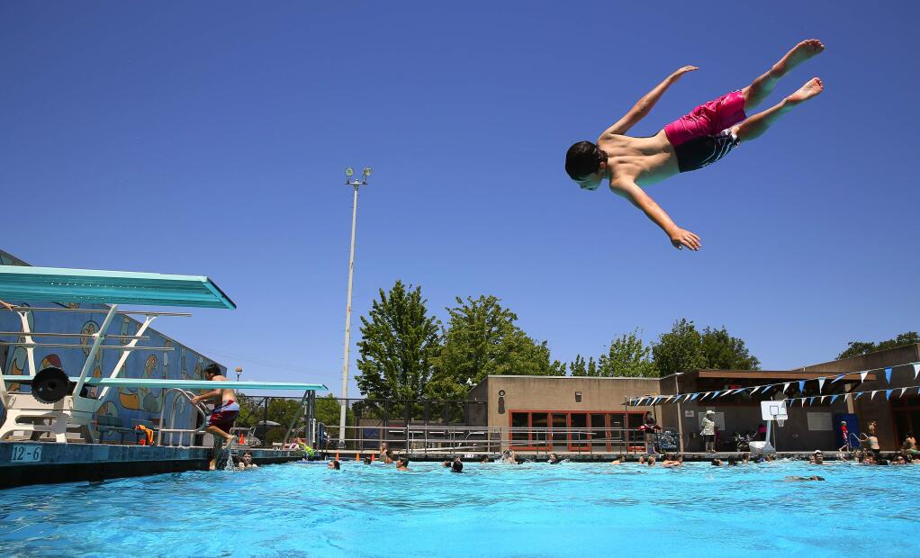 Nate Schank, 12, jumps off a diving board into a pool at the Finley Aquatic Center in Santa Rosa. (Christopher Chung/PD FILE)