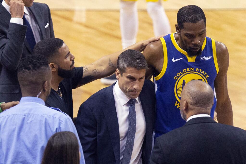Golden State Warriors forward Kevin Durant, right, is consoled by Drake as he walks off the court after sustaining an injury during first half basketball action in Game 5 of the NBA Finals against Toronto Raptors in Toronto, Monday, June 10, 2019. (Chris Young/The Canadian Press via AP)
