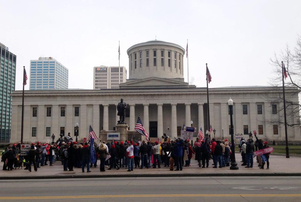 Supporters and opponents of president Donald Trump face off in front of the Ohio state house in Columbus, Ohio on Saturday, March 4, 2017. The extraordinary clash of several hundred people in one of America's most closely-divided battleground states featured chanting and name-calling as well as opposing activists leaning in to try to hear each other out on the unconventional president. (AP photo/Julie Carr Smyth)