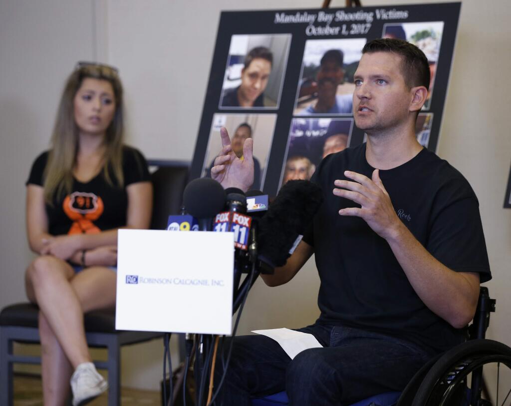 Jason McMillan, 36, of Riverside, a Riverside County Sheriff's deputy who was shot and paralyzed in the Oct, 1, 2017, Las Vegas shooting, talks about that evening and is upset MGM's decision, during a personal account brought together by attorneys at a news conference in Newport Beach, Calif., Monday, July 23, 2018. His fiance Fiorella Gaeta sits at left. Victims of the fatal mass shooting at a Las Vegas country music festival are outraged they are being sued by MGM, which owns the hotel where the gunman opened fire. (AP Photo/Alex Gallardo)