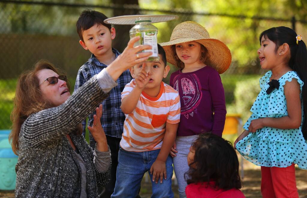 Preschool teacher Devra Newhouse, left, holds up a jar containing a caterpillar for Wyatt Em, Miguel Favela, Esmeralda Freedheim, Gael Ambriz-Sanchez and Nataly Pablo to look see, at Willow Creek State Preschool in Santa Rosa, on Wednesday, March 30, 2016. (Christopher Chung/ The Press Democrat)