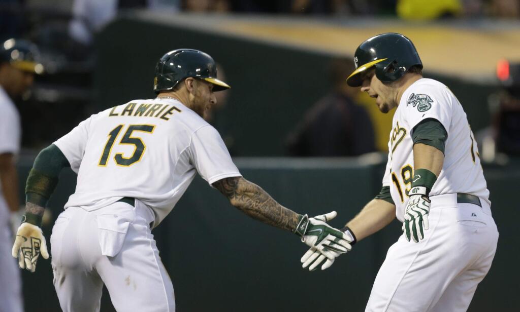 Oakland Athletics' Josh Phegley, right, is congratulated by Brett Lawrie (15) after hitting a two run home run against the Tampa Bay Rays in the sixth inning of a baseball game Saturday, Aug. 22, 2015, in Oakland, Calif. (AP Photo/Ben Margot)