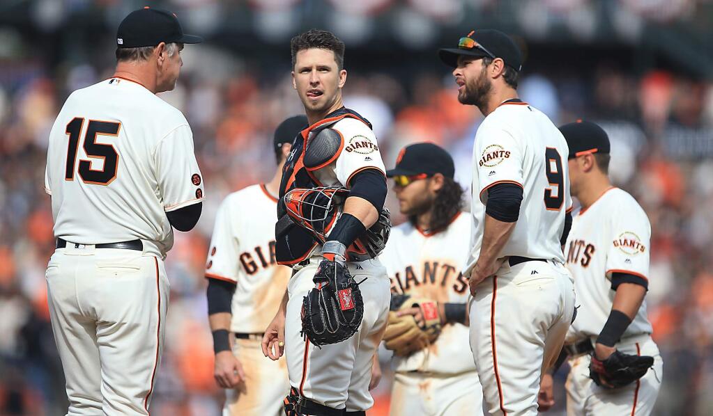 Buster Posey contemplates a Giants pitching change during the home opener against the Dodgers in San Francisco in 2016. (Kent Porter / The Press Democrat)