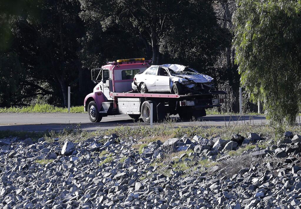 A tow truck hauls away a car that was driven by Jayda Jenkins above Alameda Creek near Fremont, Calif., Tuesday, Jan. 24, 2017. (AP Photo/Jeff Chiu)