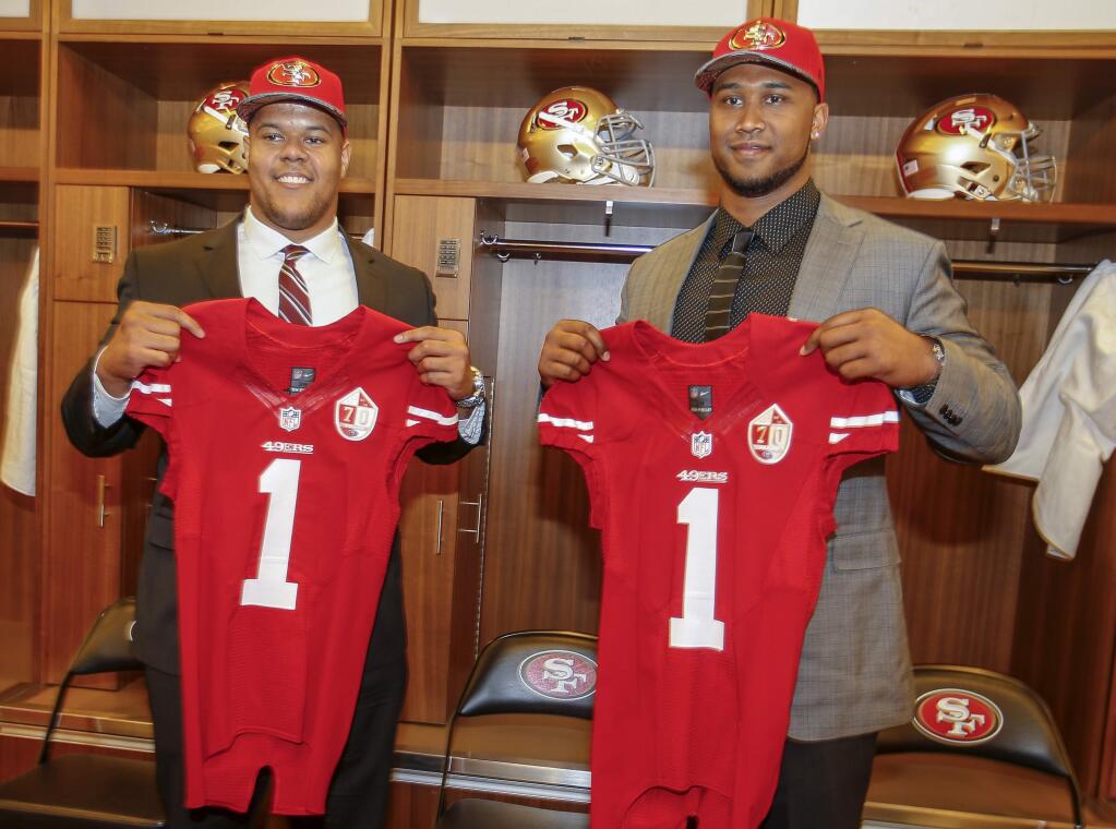 San Francisco 49ers NFL first round draft picks, Joshua Garnett, left, a guard from Stanford, and DeForest Buckner, right, a defensive lineman from Oregon, pose for a photo in the locker room during an NFL news conference in Santa Clara, Calif., Friday, April 29, 2016. (AP Photo/Tony Avelar)