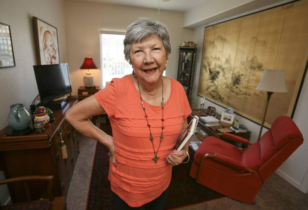 Author Helen Mossman, holds the book she wrote about the two years she spent hiding in the jungle from Japanese soldiers during WWII, in her Petaluma home on Monday September 15, 2014. (SCOTT MANCHESTER/ARGUS-COURIER STAFF)