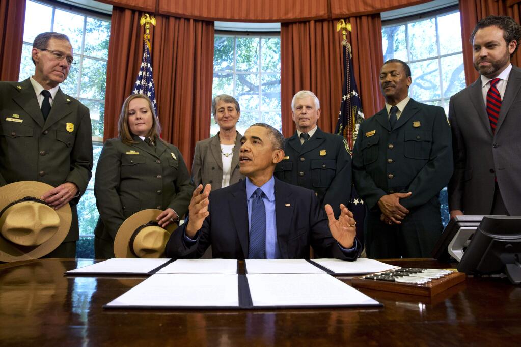 President Barack Obama, center, talks about the designation of three new national monuments; Berryessa Snow Mountain in California, Waco Mammoth in Texas, and the Basin and Range in Nevada, in the Oval Office of the White House Friday, July 10, 2015, in Washington. Behind him from left are Victor Knox, associate director of park planning, facilities and lands of the National Park Service; April Slayton, chief of public affairs and chief spokesperson of the National Park Service; Secretary of the Interior Sally Jewell; U.S. Forest Service Chief Tom Tidwell; Randy Moore, Forest Service; and Bureau of Land Management director Neil Kornze. (AP Photo/Jacquelyn Martin)