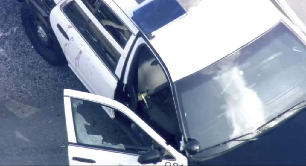 In this image provided courtesy of KTVU-TV is a San Francisco police patrol car with a shattered front passenger window and blood splattered on a side door at a shooting scene Friday, Dec. 1, 2017, in San Francisco. San Francisco police are investigating the officer-involved shooting in the city's Bayview neighborhood. (Courtesy of KTVU-TV via AP)