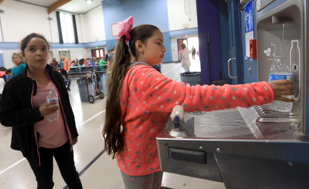 Ayleen Arellano and Tiffany Antonio fill their water bottles at lunch, Tuesday, May 15, 2018 at Sheppard Accelerated Elementary School in Santa Rosa. (Kent Porter / The Press Democrat) 2018