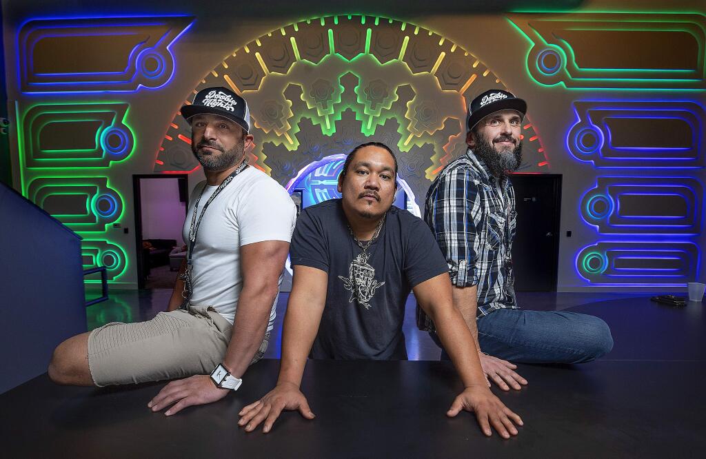 Co-owners Brandon Levine, left, and Damon Crain, right, with creative and technical director Donnie Penales in the check-in room at the new Doobie Nights marijuana dispensary in Santa Rosa. (photo by John Burgess/The Press Democrat)