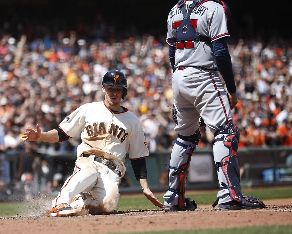 San Francisco Giants' Matt Duffy scores a run past Atlanta Braves catcher Christian Bethancourt (27) on a single by Gregor Blanco during the seventh inning of a baseball game, Sunday, May 31, 2015, in San Francisco. (AP Photo/Tony Avelar)