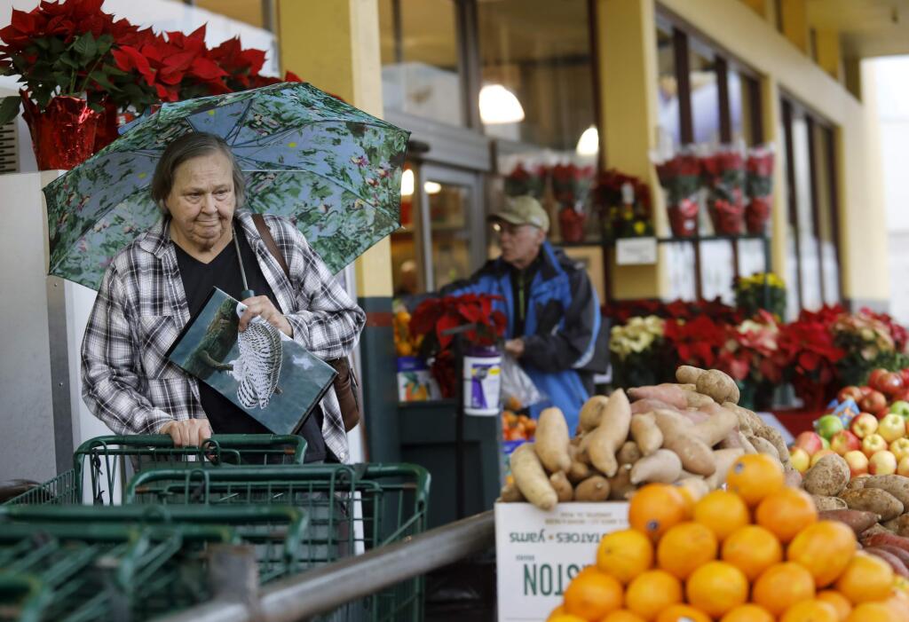 Virginia Pratt, left, grabs a cart before picking up her turkey and some groceries at the Petaluma Market in Petaluma on Wednesday, November 21, 2018. (BETH SCHLANKER/ The Press Democrat)
