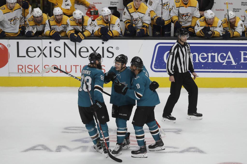 Nashville Predators players, top, watch as San Jose Sharks right wing Timo Meier, bottom center, is congratulated by defenseman Brent Burns, left, and left wing Evander Kane after scoring in the shootout in San Jose, Saturday, Nov. 9, 2019. The Sharks won 2-1. (AP Photo/Jeff Chiu)