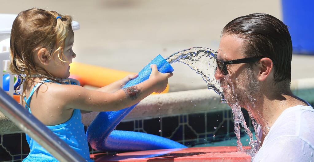 Camille Thielman, 2, and her father Brendan cool off at the YMCA pool in Cloverdale, where the temperature was a balmy 95 degrees on Monday June 29, 2015. (Kent Porter / Press Democrat)