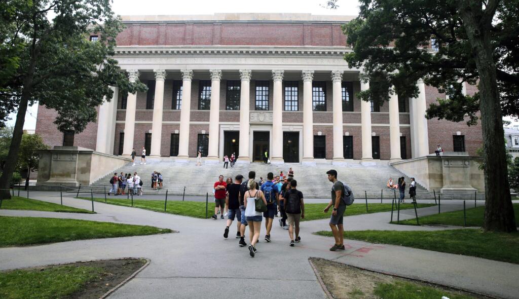 FILE - In this Aug. 13, 2019 file photo, students walk near the Widener Library in Harvard Yard at Harvard University in Cambridge, Mass. I (AP Photo/Charles Krupa, File)