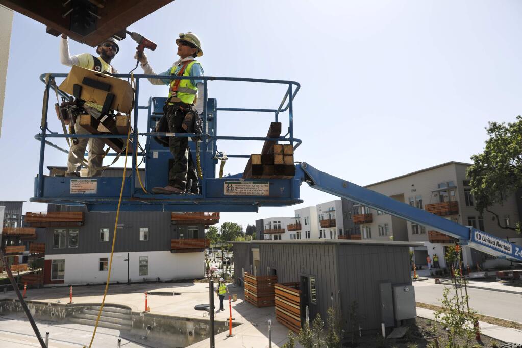 Ramon Avellar, left, and Hilario Garcia of Katerra Construction work on building a balcony as they complete new units of the Annadel apartment complex on Monday, April 30, 2018 in Santa Rosa, California . (BETH SCHLANKER/The Press Democrat)