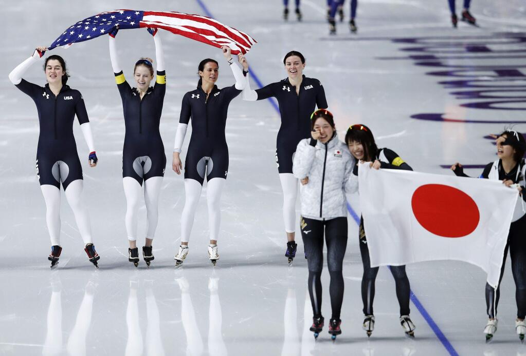Gold medalist team Japan, front, and bronze medalist team U.S.A. celebrate after the women's team pursuit speedskating race at the Gangneung Oval at the 2018 Winter Olympics in Gangneung, South Korea, Wednesday, Feb. 21, 2018. (AP Photo/Vadim Ghirda)