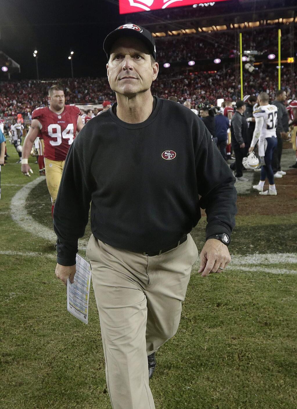 San Francisco 49ers coach Jim Harbaugh walks off the field after the 49ers lost 38-35 in overtime to the San Diego Chargers in an NFL football game in Santa Clara, Calif., Saturday, Dec. 20, 2014. (AP Photo/Marcio Jose Sanchez)