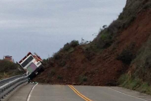 A roads worker escaped injury after a landslide toppled his dump truck on Highway 1 in Mendocino County on Friday, March 11, 2016. (CALTRANS DISTRICT 1)