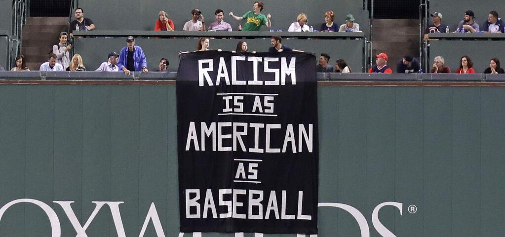 A banner is unfurled over the left field wall during the fourth inning of a game between the Boston Red Sox and Oakland Athletics at Fenway Park in Boston, Wednesday, Sept. 13, 2017. (AP Photo/Charles Krupa)