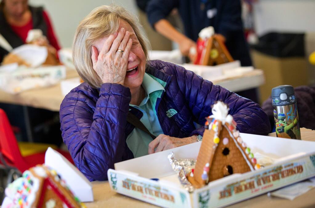 Children and their parents used M&M's, Fruit Loops, dummies, and plenty of licorice to create their own Snoopy's doghouse out of gingerbread complete with a marshmallow Snoopy on top on Saturday at the Charles M. Schulz Museum on Saturday. (photo by John Burgess/The Press Democrat)
