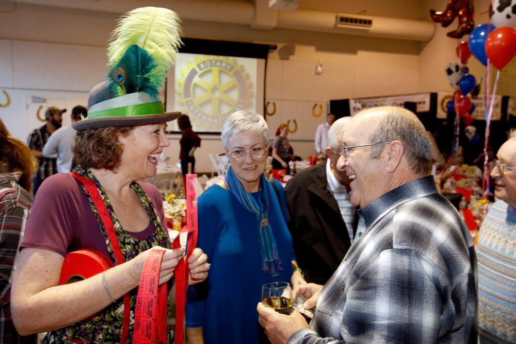 Lori Bruhner, left, sells raffle tickets to Reggie and Larry Deis during the 31st annual Russian River Rotary Crab Feed at Shone Farm, in Santa Rosa, California, on Saturday, January 27, 2018. (Alvin Jornada / The Press Democrat)