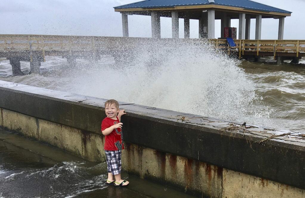 Jordan Fortune, 3, laughs as a wave churned up by Tropical Depression Cindy hits a sea wall at the harbor in Pass Christian, Miss., on Thursday, June 22, 2017. (AP Photo/Jay Reeves)(AP Photo/Jay Reeves)