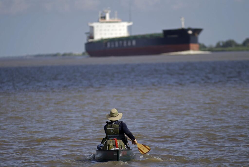 Joshua Ploetz, a Marine who fought in Afghanistan, canoes in the Mississippi River near Venice, La., Sunday, July 27, 2014. Ploetz, who has been dealing with Post Traumatic Stress Syndrome, has been canoeing the entire Mississippi River. The trip to the mouth of the river at the Gulf of Mexico would take 69 days, about 50 of them spent paddling. But Ploetz said he needed every inch of the more than 2,500-mile river to paddle away the demons of the war, or at least calm them a bit. (AP Photo/Gerald Herbert)