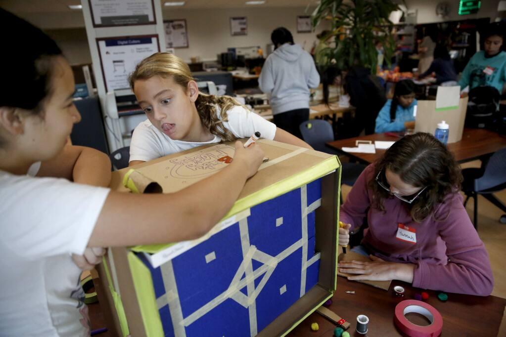 Gia Bettinelli, 11, center, Silvia Olvera, 13, left, and Hannah Berkheimer, 13, work to build a hockey arcade game during the Girls Tinker Academy in the makerspace on the Sonoma State University campus in Rohnert Park on Monday, July 30, 2018. (Beth Schlanker/ The Press Democrat)