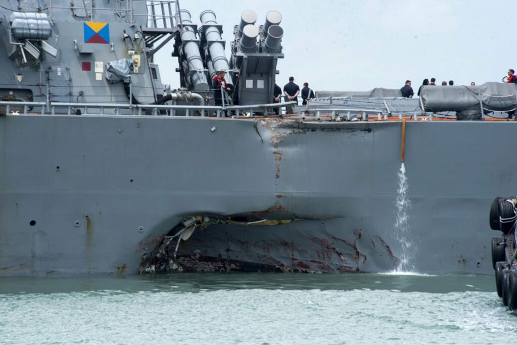 Damage to the portside is visible as the Guided-missile destroyer USS John S. McCain (DDG 56) steers towards Changi naval base in Singapore following a collision with the merchant vessel Alnic MC Monday, Aug. 21, 2017. The USS John S. McCain was docked at Singapore's naval base with 'significant damage' to its hull after an early morning collision with the Alnic MC as vessels from several nations searched Monday for missing U.S. sailors. (Mass Communication Specialist 2nd Class Joshua Fulton/U.S. Navy photo via AP)