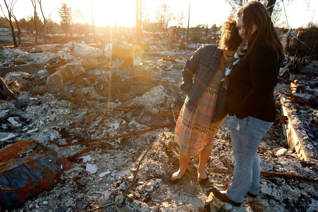 Amy Marlar embraces her daughter Logyn, 11, as they stand on what used to be the front porch of their Santiago Drive home that was destroyed by the Tubbs Fire, in the Coffey Park neighborhood of Santa Rosa, California on Wednesday, December 20, 2017. (Alvin Jornada / The Press Democrat)