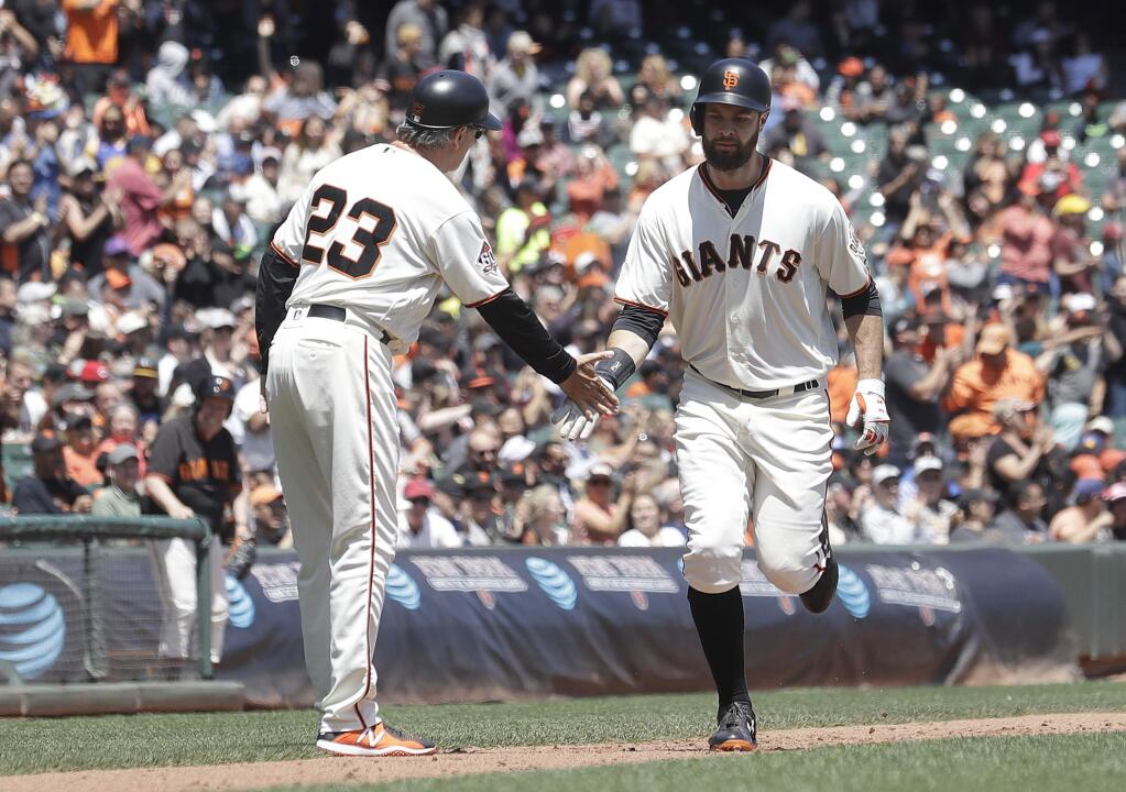 The San Francisco Giants' Brandon Belt, right, is congratulated by third base coach Ron Wotus after hitting a home run against the Cincinnati Reds in the third inning in San Francisco, Wednesday, May 16, 2018. (AP Photo/Jeff Chiu)