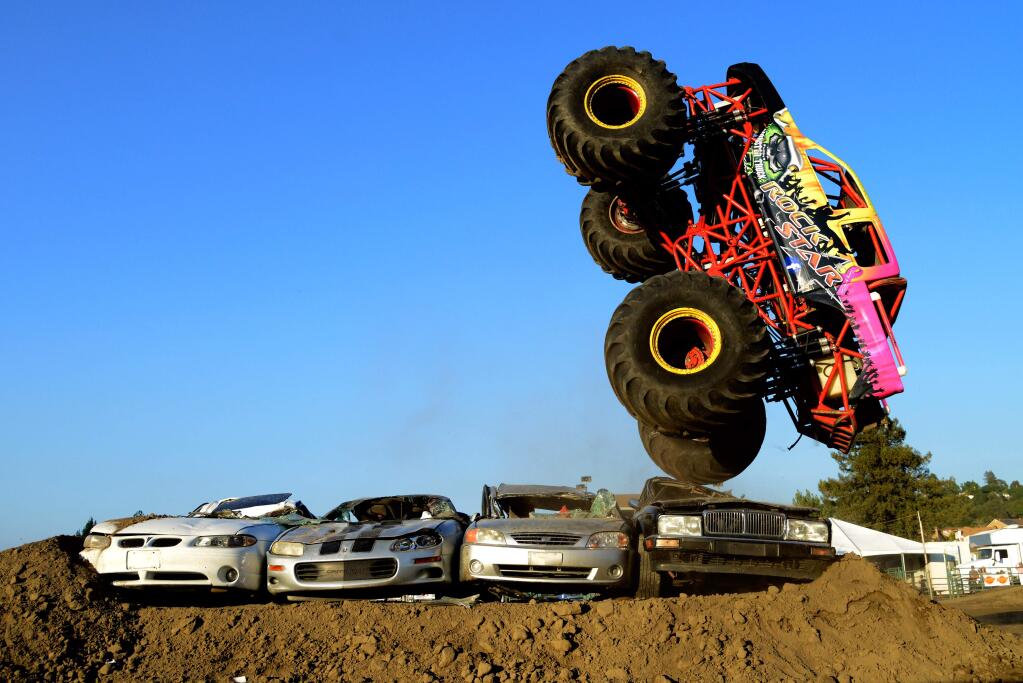 Monster truck Rock Star goes vertical as it jumps a row of cars during a monster truck show at the Sonoma County Fairgrounds in Santa Rosa, California, on August 8, 2015.