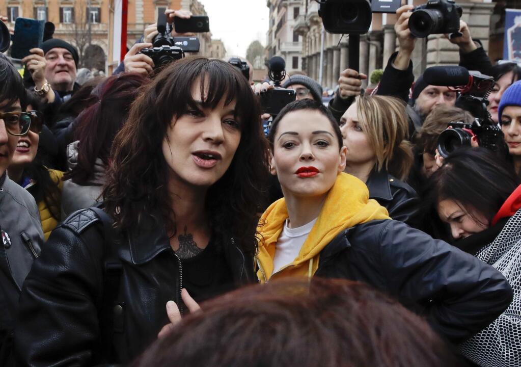 FILE - In this March 8, 2018 file photo, actresses Asia Argento, left, and Rose McGowan pose during a demonstration to mark the international Women's Day in Rome. Argento, one of the most prominent activists of the #MeToo movement against sexual harassment, recently settled a complaint filed against her by a young actor and musician who said she sexually assaulted him when he was 17, the New York Times reported. (AP Photo/Alessandra Tarantino, File)