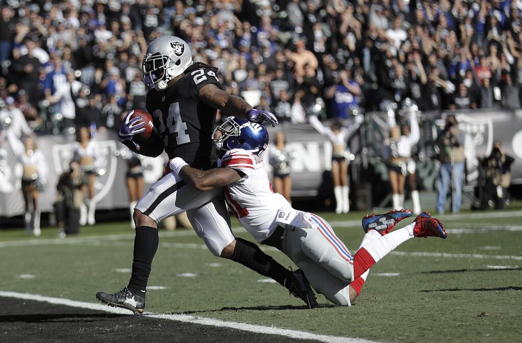 In this Dec. 3, 2017, file photo, Oakland Raiders running back Marshawn Lynch scores a touchdown in front of New York Giants cornerback Dominique Rodgers-Cromartie during the first half in Oakland. (AP Photo/Marcio Jose Sanchez, File)